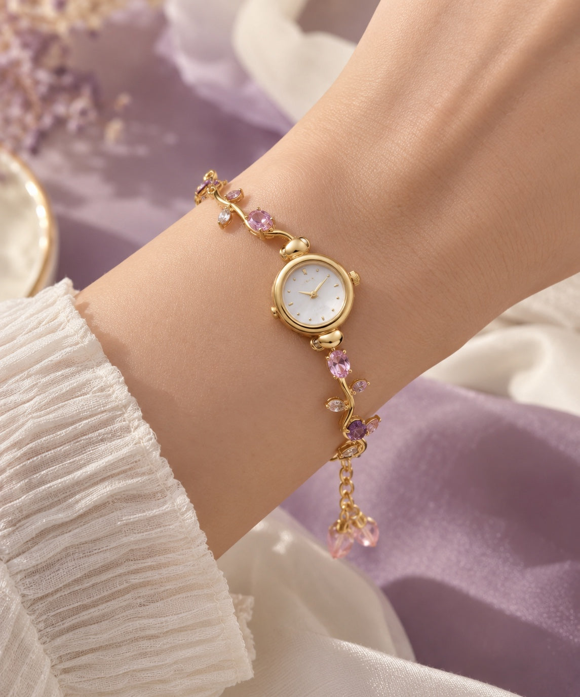Pink floral gold-tone bracelet watch worn on wrist
